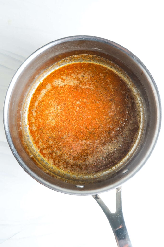 Salsa burbujeando en una olla antes de espesar.