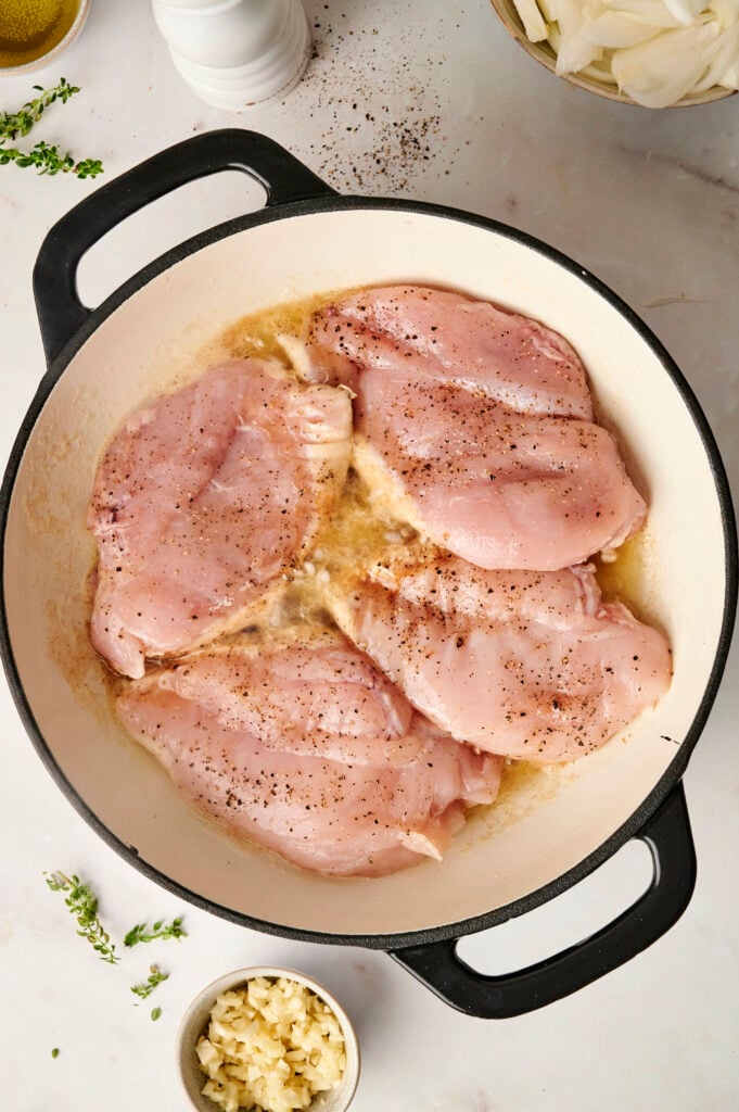 Pechugas de pollo cociéndose en una sartén.