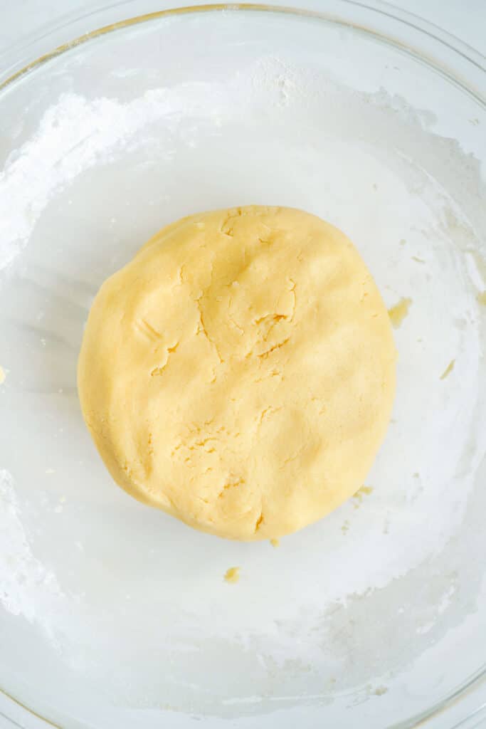 Masa de galleta de azúcar formada en una bola en un tazón de vidrio.