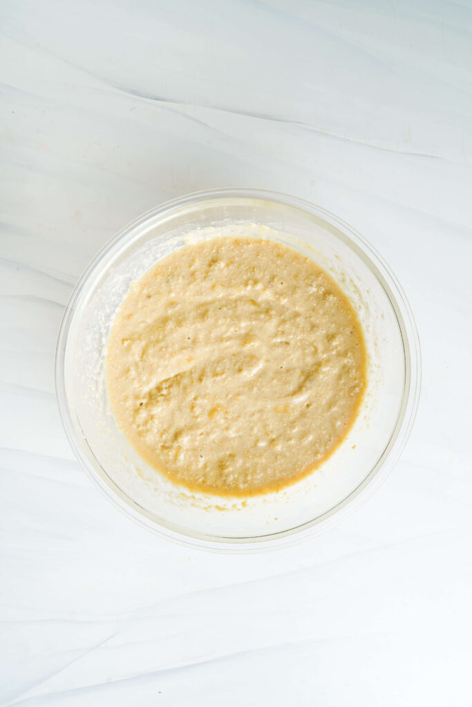 Masa de pastel de plátano suave mezclada y lista para verter en el molde para hornear.