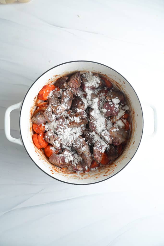 Espolvorea la mezcla con harina de trigo para espesar la salsa de la Receta de Estofado de Carne | saborinspirado.com