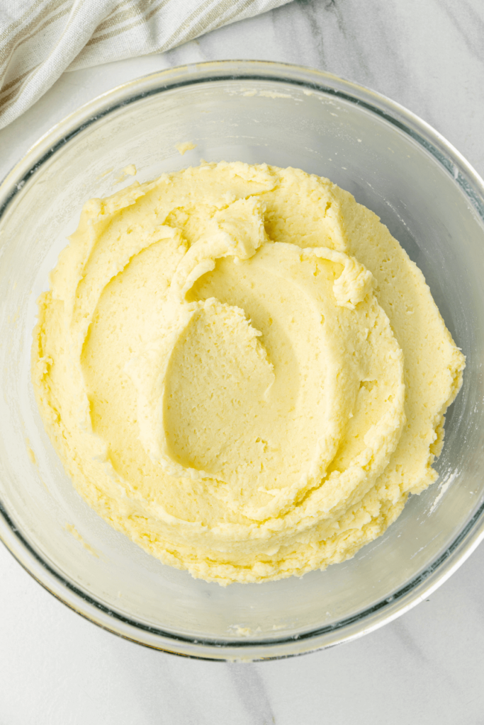 Puré de patatas en un bol de vidrio, suave y listo para ser servido con mantequilla y especias.