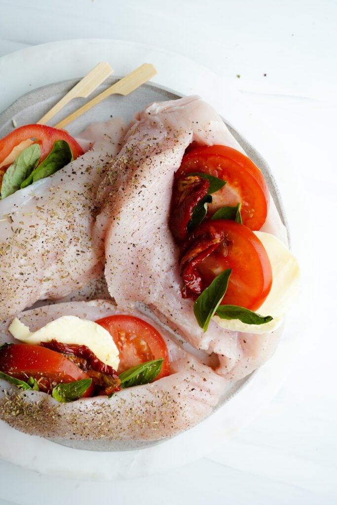 Pollo Crudo con condimentos, tomates y hierbas secas | saborinspirado.com
