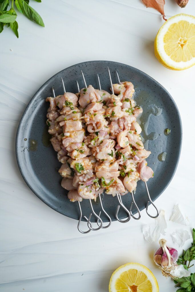 Trozos de pollo marinados ensartados en pinchos