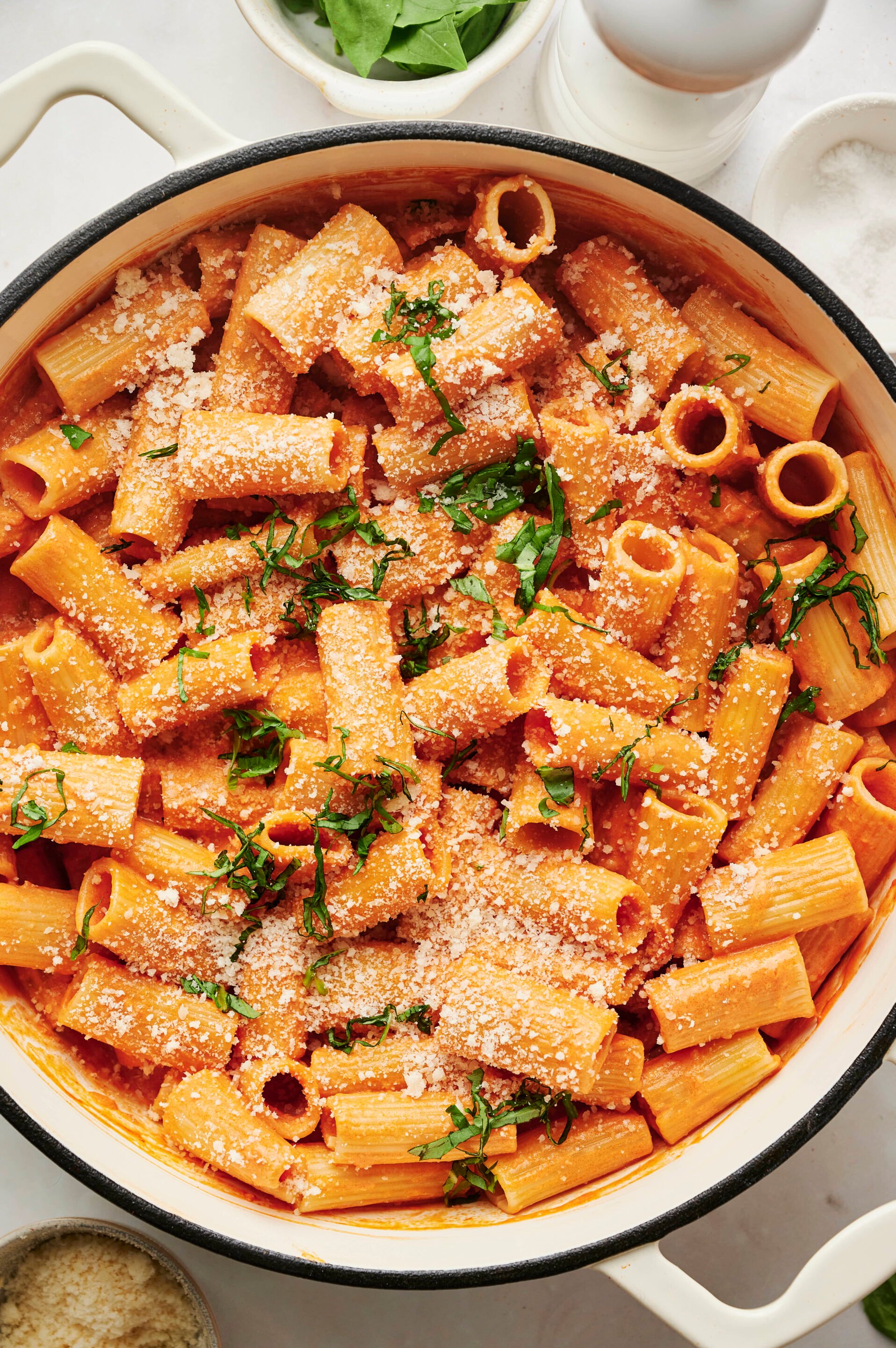 Olla de Pasta alla Vodka cubierta con queso parmesano recién rallado y albahaca fresca