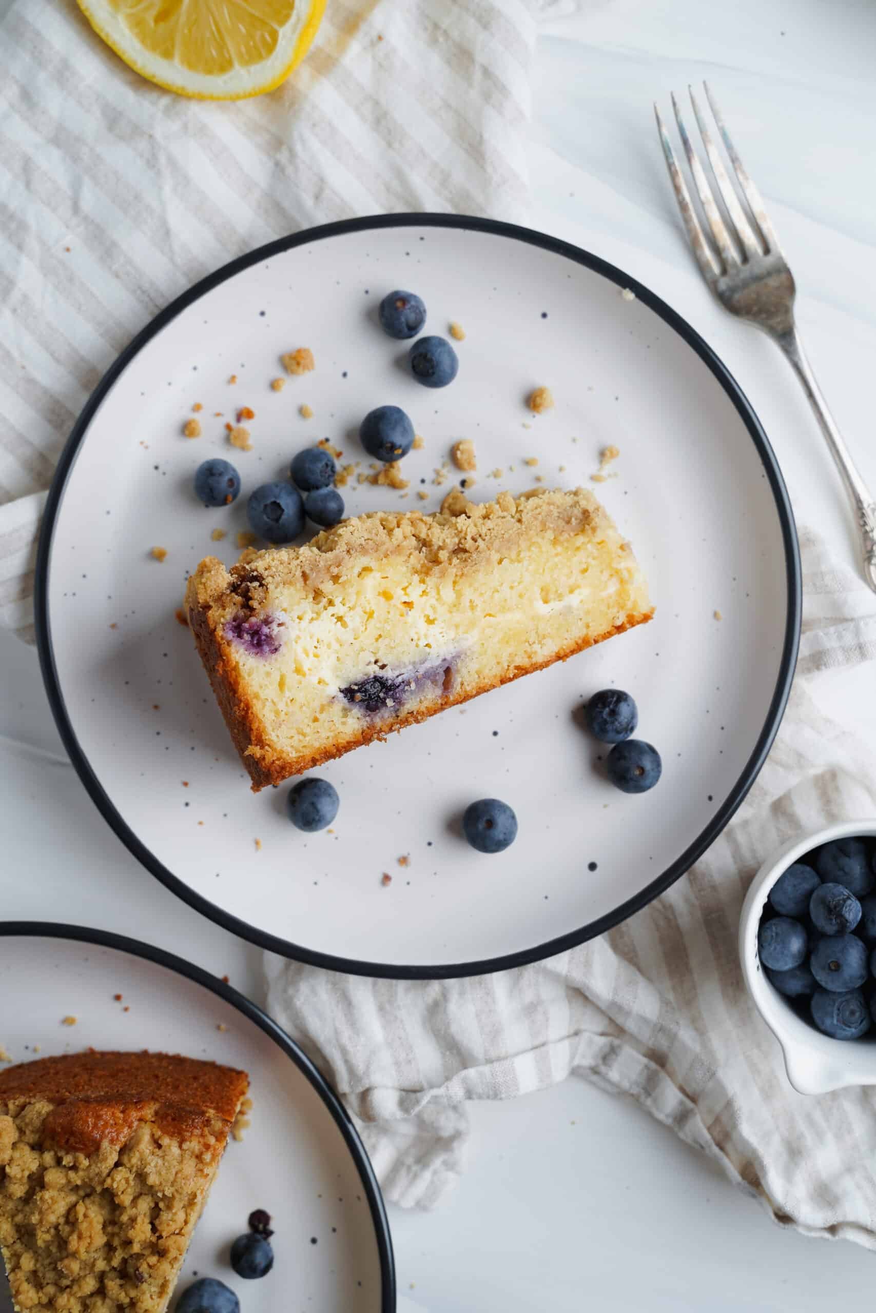 Porción de pastel de limón y arándano con arándanos frescos al lado | saborinspirado.com